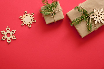 Handmade Christmas decorations and presents wrapped fir tree branches on red background. Flat lay, top view, copy space. Christmas, winter, New year concept. Greeting card template