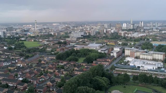 Aerial cityscape across Liverpool city buildings, cathedral, radio city tower along skyline. Wide orbit right