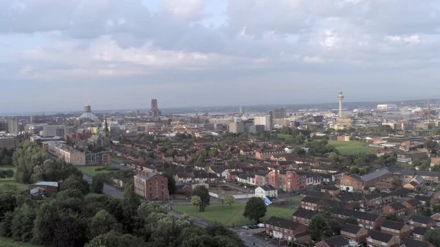 Aerial cityscape across Liverpool city buildings, cathedral, radio city tower along skyline. Left slow wide orbit.