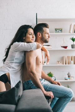attractive and brunette woman in shirt hugging with handsome man