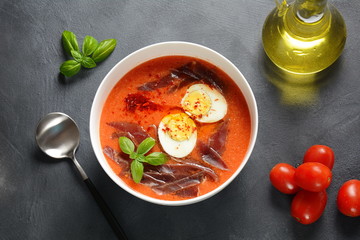 Traditional Spanish andalusian tomato cream soup Salmorejo served with egg, ham jamon in a bowl. Summer cold soup concept 