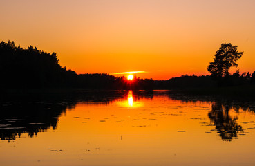 Plakat Bright orange sunset over a quiet lake
