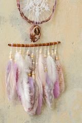 Closeup details modern dreamcatcher with gemstones, crochet doily snowflake, painted feathers, cinnamon stick, star anise