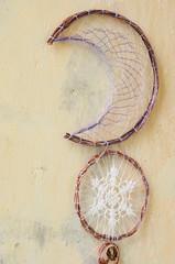 Closeup details modern dreamcatcher with gemstones, crochet doily snowflake, painted feathers, cinnamon stick, star anise