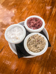 3 different types os salt on small white containers.