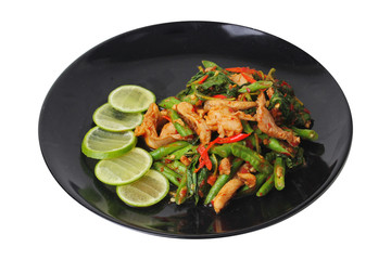 Thai cuisine , Spicy fried cowpea and basil with pork topped sliced green lemon on black plate