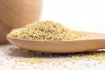 Organic Healthy millet in spoon isolate on white background.