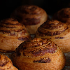 close up fresh puff pastry rolls with ham and cheese on baking pan board. A tray with fresh bakery products bread puff pastry at a local bakery. Top view