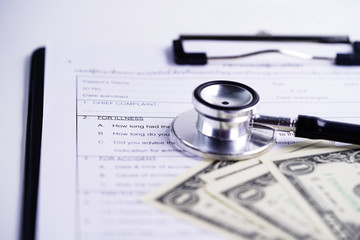Health insurance accident claim form with stethoscope and US dollar banknotes, Medical concept.    
