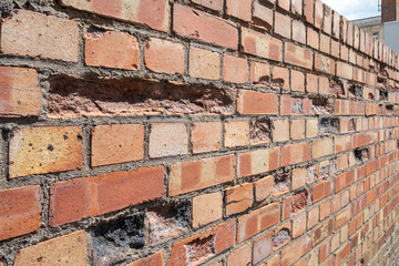 Damaged brick wall with blown bricks