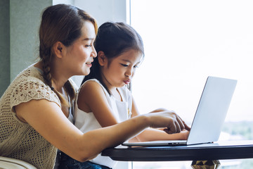 Mother and daughter using laptop together