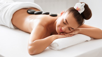 Obraz na płótnie Canvas Spa treatment. Woman enjoying hot stone massage