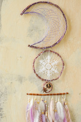Closeup details modern dreamcatcher with gemstones, crochet doily snowflake, painted feathers,...