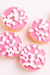 Colorful cupcakes on a pink background.