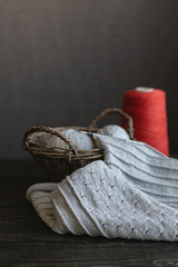 Fototapeta na wymiar Grey knitting with red yarn in a basket.