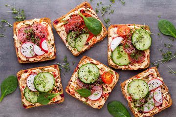 Sandwiches with cream cheese, vegetables and salami.