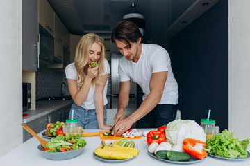 Close Up couple portrait- woman eating kiwi. Man prepared salad. - Concept healthy food