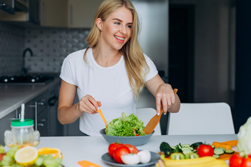 Obraz na płótnie Canvas Happy woman mixing a salad.- Concept healthy food