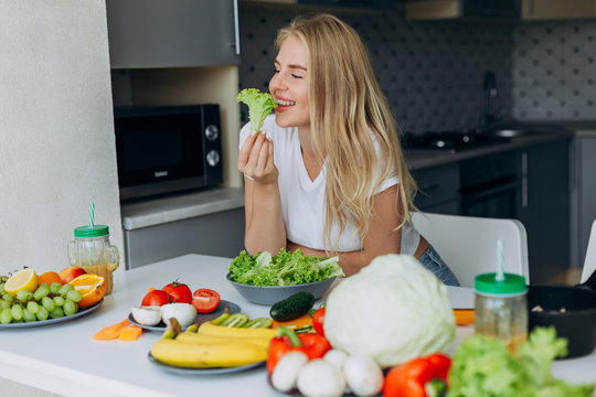 Portrait of happy woman at the table eating a healthy food. - Image