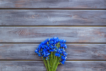 Summer flowers pattern with blue cornflowers on wooden background top view mock up