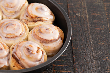 Cinnamon Rolls in a Pan on a Rustic Wooden Table