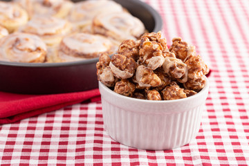 Cinnamon Roll Flavored Gourmet Popcorn on a Red and White Plaid Tablecloth
