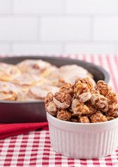 Cinnamon Roll Flavored Gourmet Popcorn on a Red and White Plaid Tablecloth