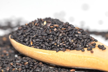Lemon basil seeds in a wooden spoon isolate on white background.
