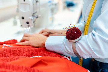 Close-up on the hand and works of an alterations tailor