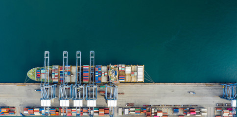 Aerial view. Container ship in pier with crane bridge carries out export and import business in the open sea. Logistics and transportation