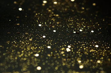 Golden sparkles on black background. Festive concept. - Image