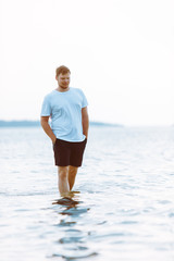 man walking barefoot by sea beach summer time