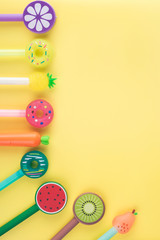 Colored pencils laid out on a yellow background, school supplies