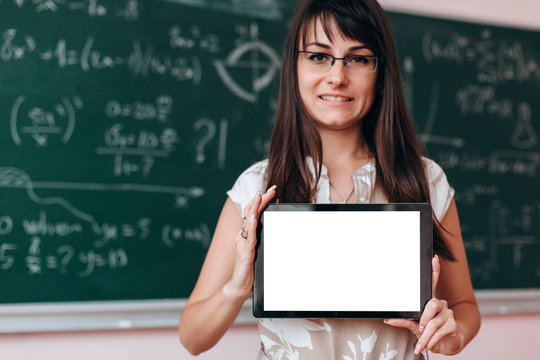 Woman holding a blank screen white mockup in her hands and looking at the camera