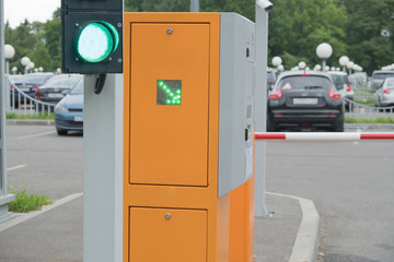 Automatic barrier in the parking lot. Resolving, green light semaphore. Green arrow. Summer, cloudy...