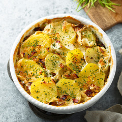 Homemade potato gratin with bacon and herbs