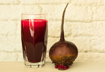  Fresh and healthy beetroot juice and beets on a white table. Close-up.