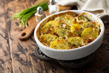 Homemade potato gratin with bacon and herbs