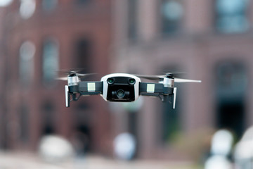 Close up of drone quadcopter inflight. Cityscape background.