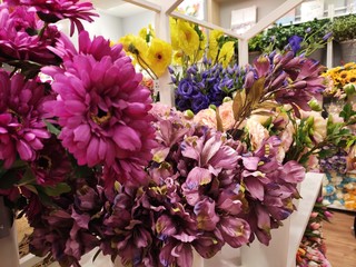 Colorful artificial flowers made of plastic display in shops for sale. 