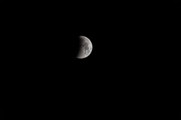 Nahaufnahme einer Mondfinsternis in den schwarzen Nachthimmel bei abnehmendem Zustand