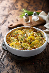 Homemade potato gratin with bacon and herbs