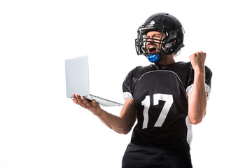 American Football player with laptop cheering with clenched hand Isolated On White © LIGHTFIELD STUDIOS