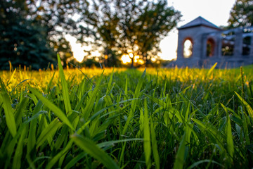 the grass of a little castle in a montain with a beatiful sunset and trees