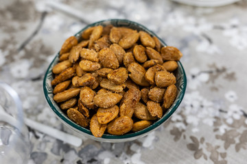 Toasted almonds on a bowl on a table with floral black and white decoration