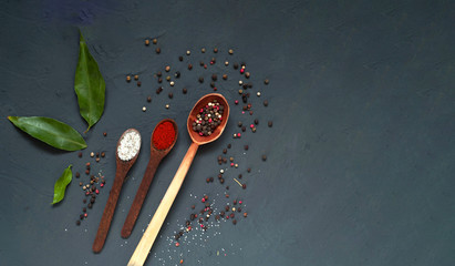Wooden spoons with spices on blue background. Close up