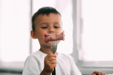 child in the kitchen eating sausage and mashed potatoes