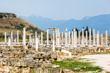 Ruin of marble columns on a background of mountains in the Ancient city of Perge near Antalya, Turkey