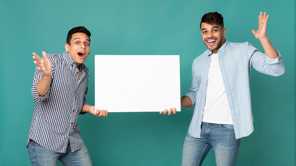 Two Excited Arab Men Showing Blank White Board, Studio Shot