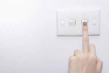 A middle finger turning on lighting switch on rough on white wall, Empty space for text your, Electric control concept, Earth hour concept, Copy space